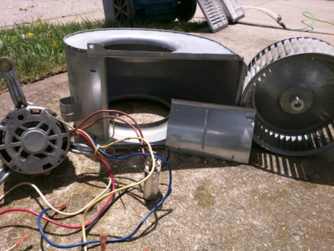 HVAC blower motor assembly with capacitor and color-coded wiring harness during replacement