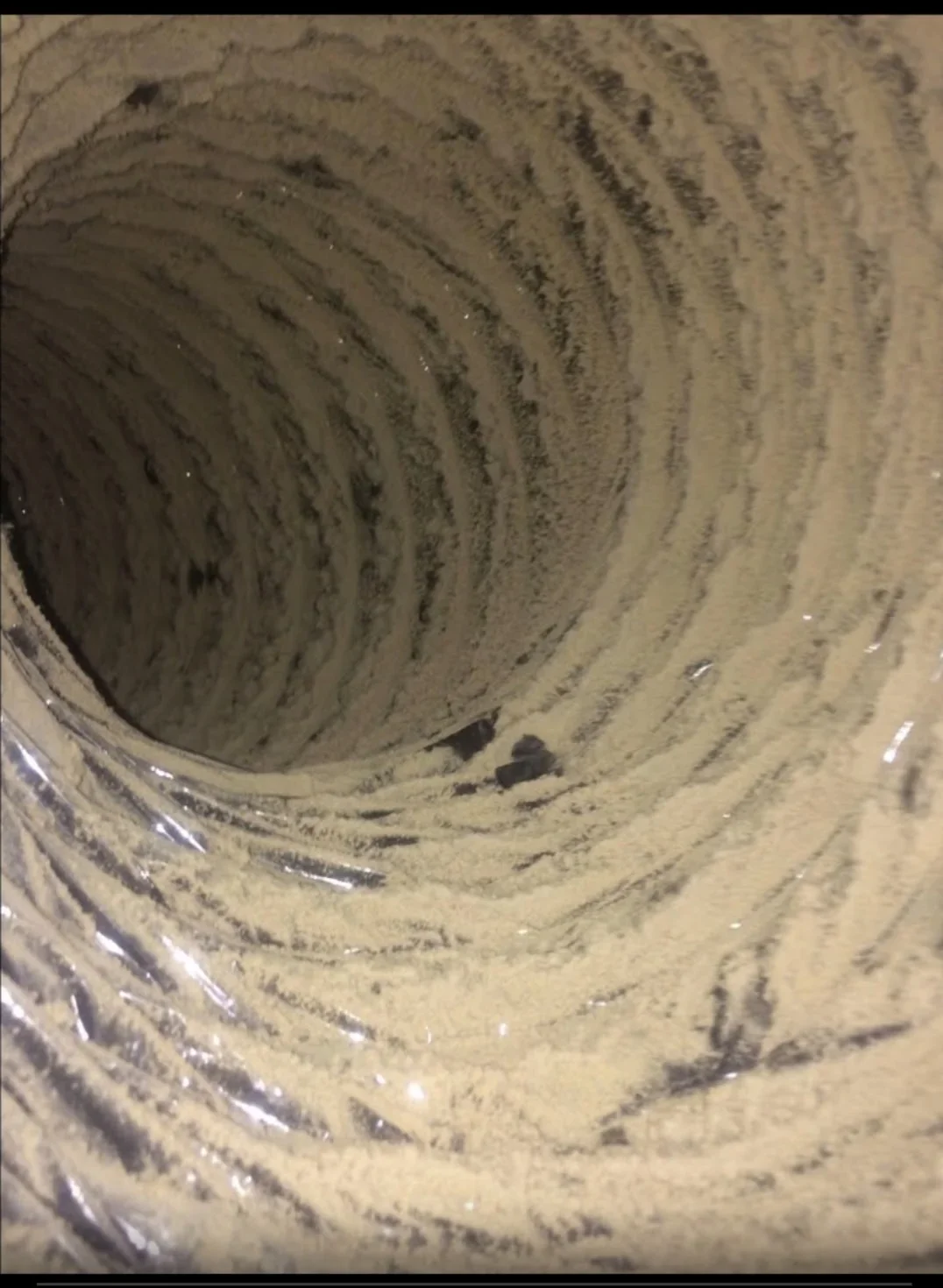 Interior ductwork with dust and debris accumulation on spiral metal seams