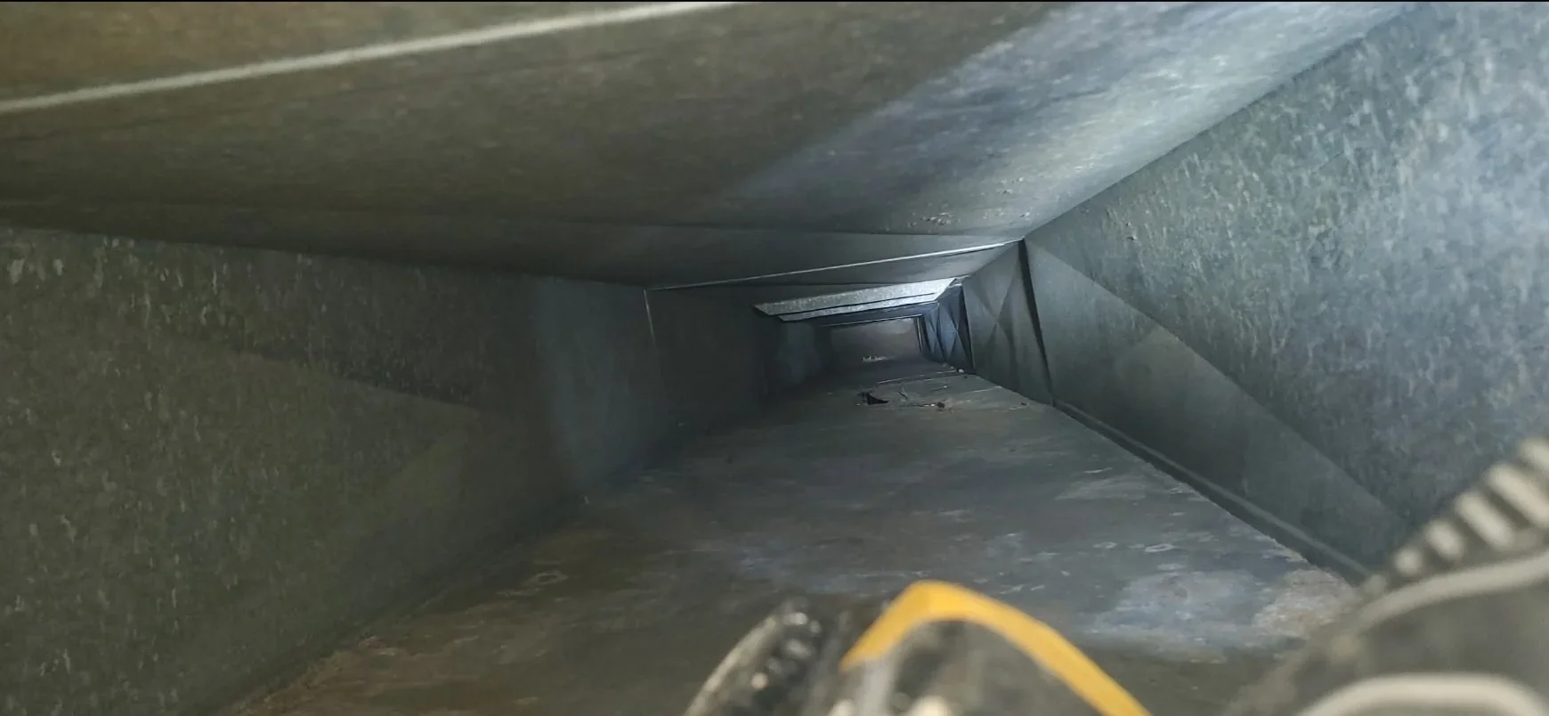 Metal ductwork with sealed joints and support straps installed in confined space