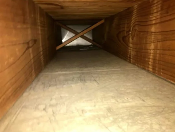 Attic space with blown-in insulation and wooden cross-bracing for ventilation support