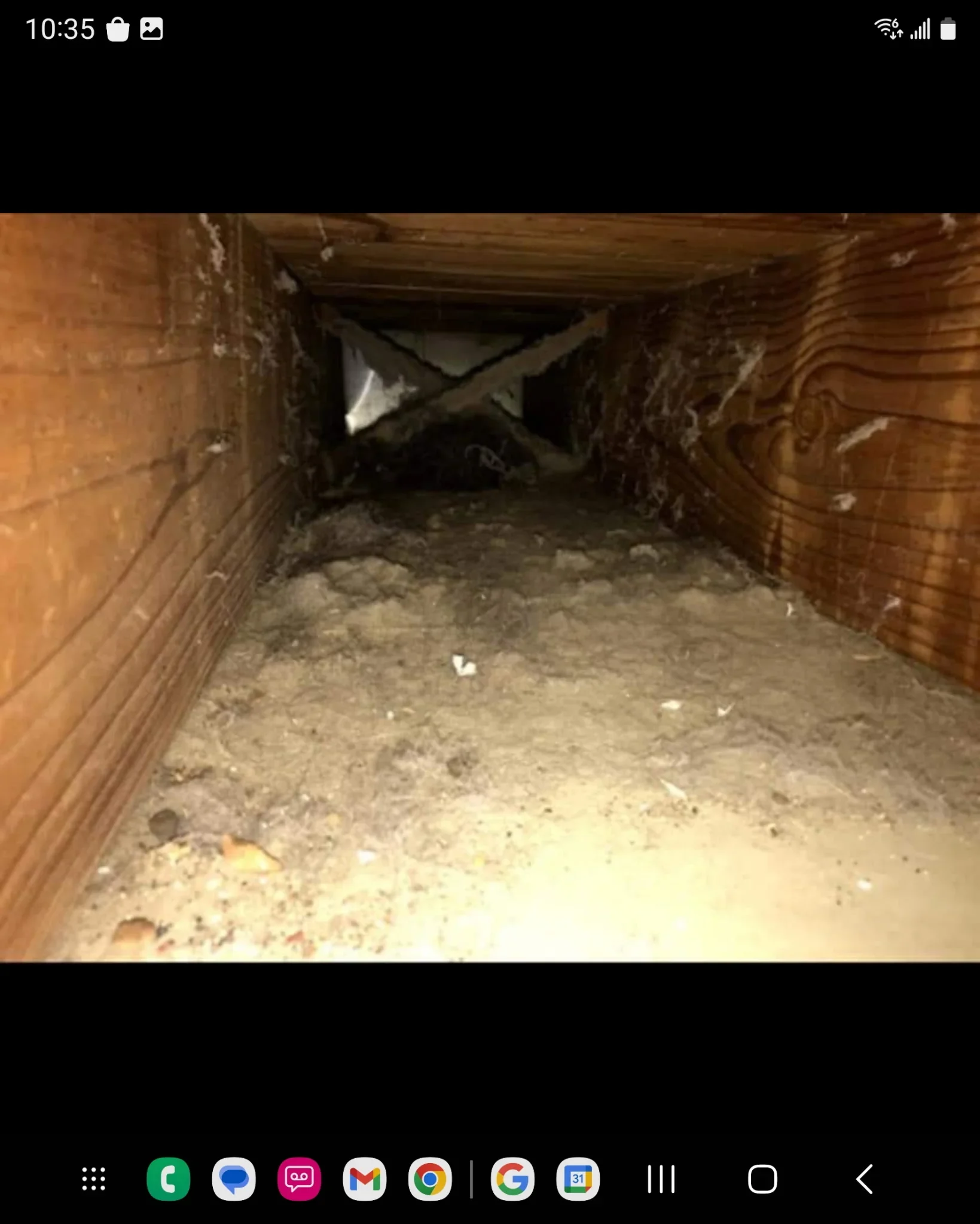 Empty crawl space with wooden framing, cleared debris, and exposed foundation