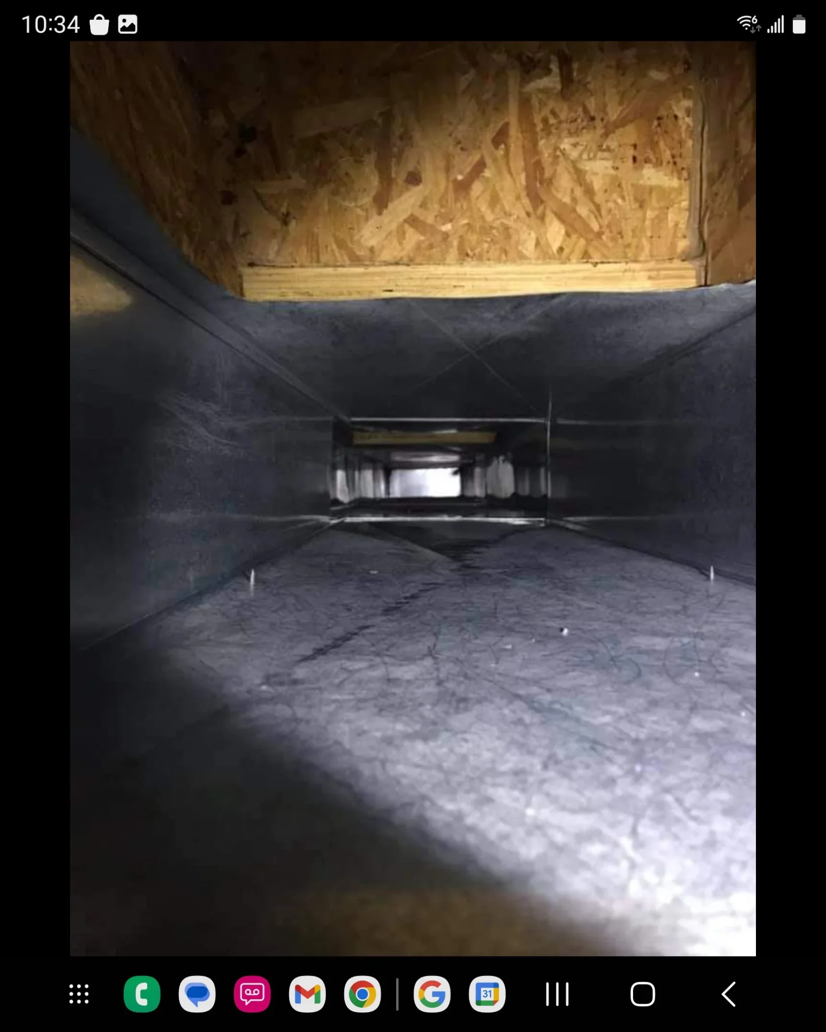 Black flex ductwork with sealed joints and support straps installed in attic cavity with OSB sheathing